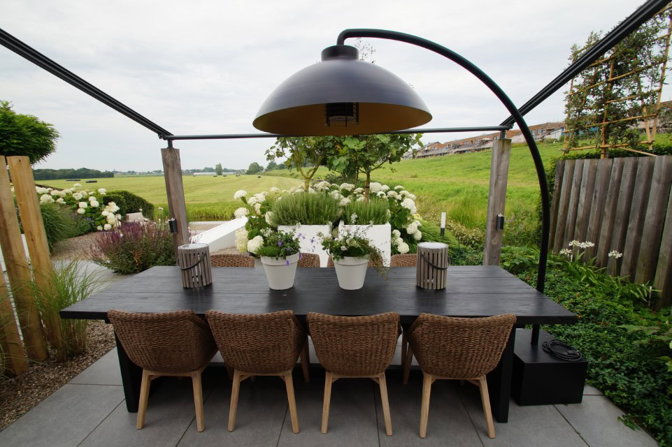 Sfeervolle achtertuin in Leimuiden met eettafel en Heatsail Dome verlichting